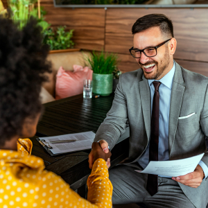 Smiling man shaking women's hand