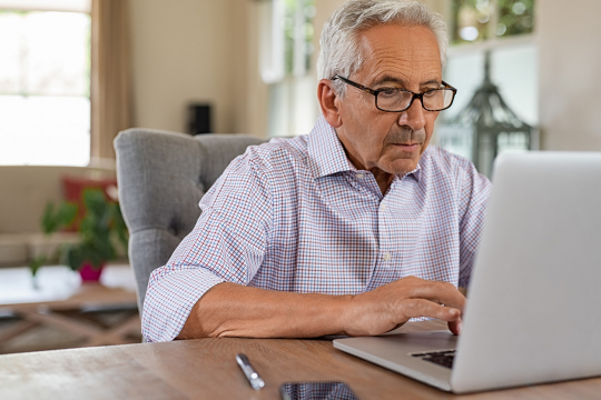 Senior man using a laptop.