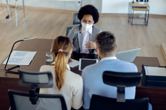 Young couple meeting with a business woman in an office.