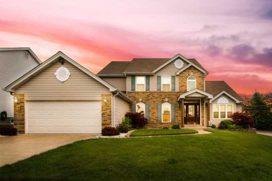 Large, modern house with an attractive front yard.