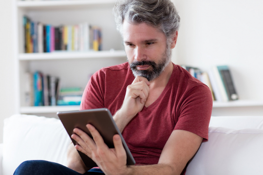 Un homme d'âge moyen utilisant une tablette.