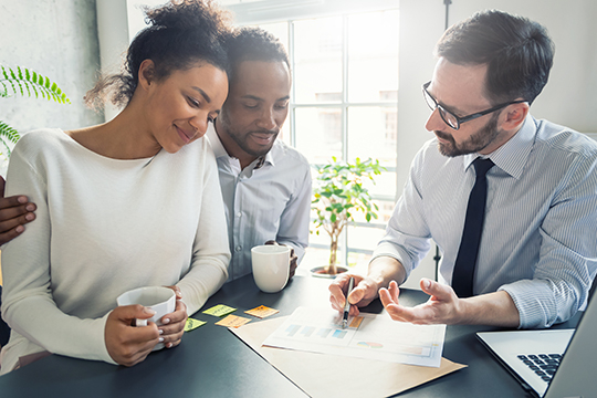 Couple heureux de parler avec leur conseiller financier