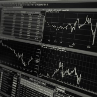 Charts and graphs on a screen depicting market fluctuations.