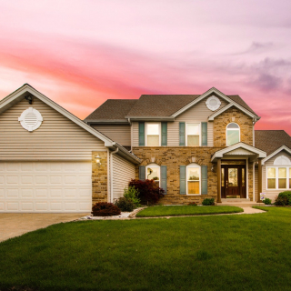 Large, modern house with an attractive front yard.