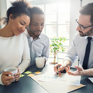 Couple heureux de parler avec leur conseiller financier