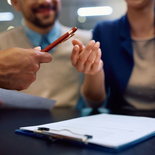 A couple preparing to sign a contract with a financial professional.