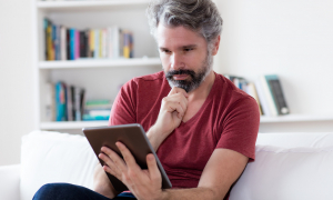 Middle aged man using a tablet.