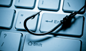 Fishing hook on a computer keyboard.