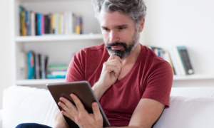 Un homme d'âge moyen utilisant une tablette.